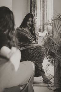 Portrait of a smiling young woman sitting at home