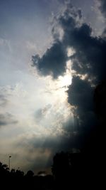 Silhouette of trees against cloudy sky