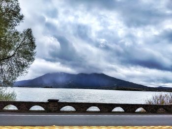 Scenic view of lake by mountains against sky