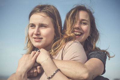 Close-up of a smiling young woman against the sky