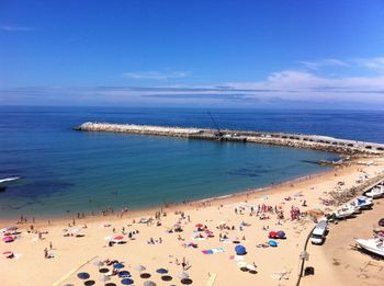 Aerial view of people at beach against blue sky
