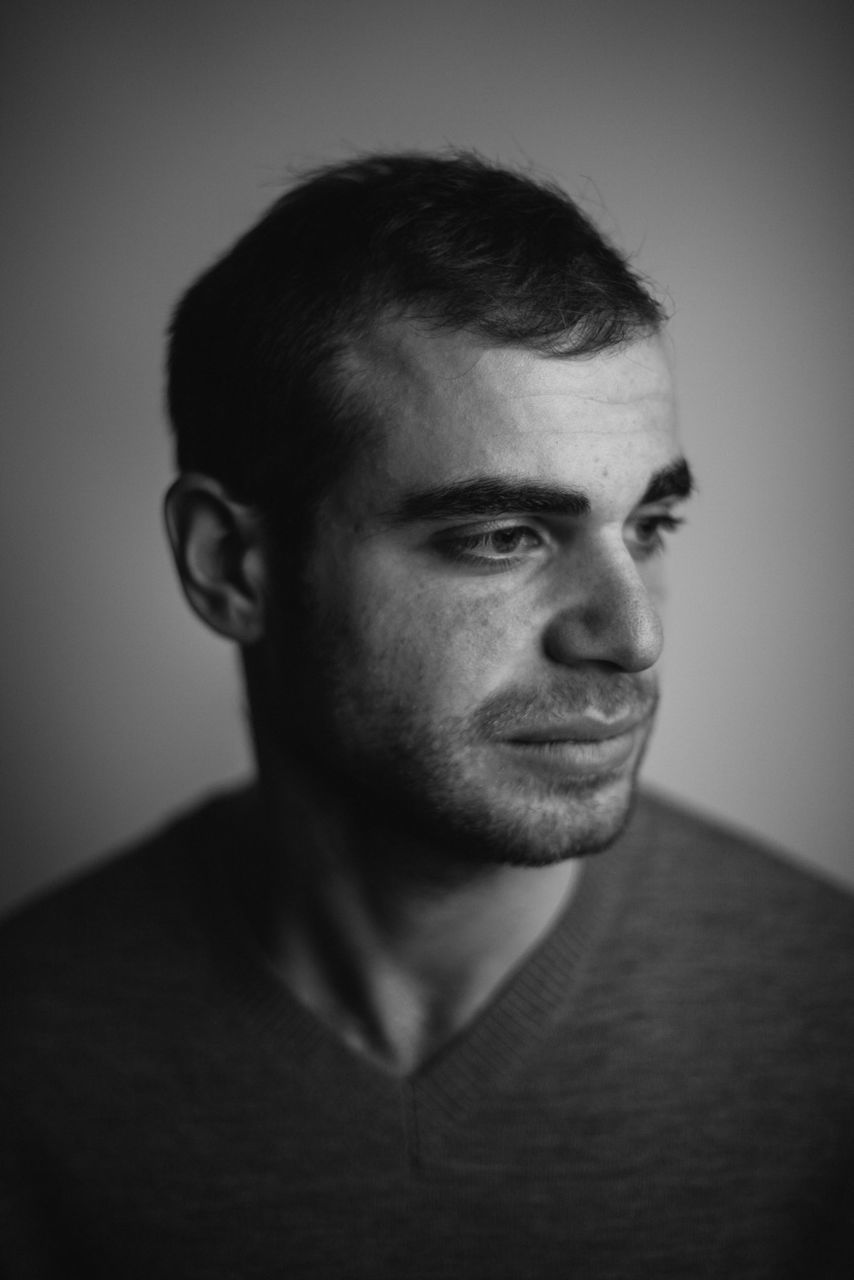 indoors, portrait, looking at camera, young adult, young men, headshot, lifestyles, front view, person, contemplation, home interior, close-up, leisure activity, serious, studio shot, confidence, mid adult, beard