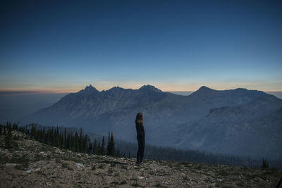 Side view of woman standing on cliff at sawtooth range