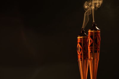 Close-up of tiki torches against brown background