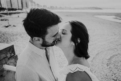 Rear view of couple kissing on land