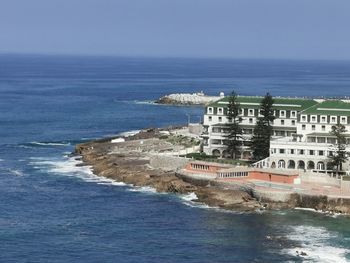 Scenic view of sea by buildings against sky