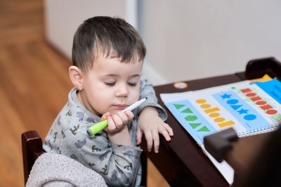 Cute boy writing at the desk