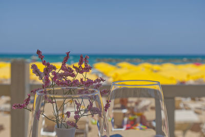 Glasses with wine for lunch with blurry beach umbrellas in the background