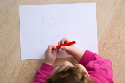 Low section of woman holding paper with text