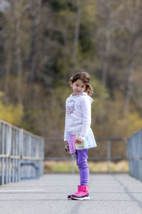 Portrait of young woman standing on railing