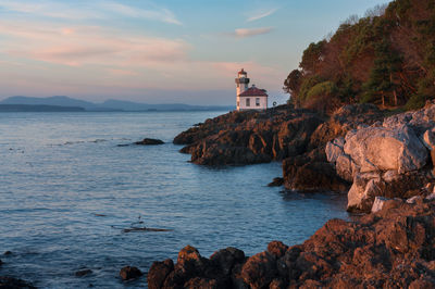 Scenic view of lime kiln lighthouse by sea against sky on san juan island