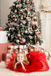 Portrait of girl with christmas tree at home