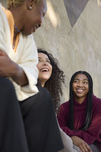 Mother talking together with smiling teenage daughters