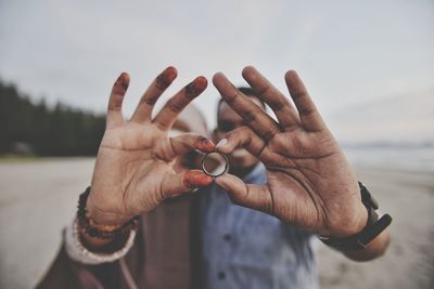 Couple hands holding finger ring at beach