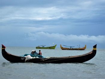 People in boat on sea against sky