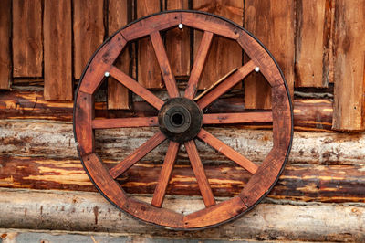 Close-up of abandoned wheel against wall