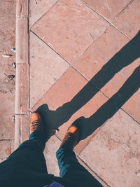 Low section of man standing on footpath