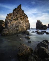 Rocks on beach against sky