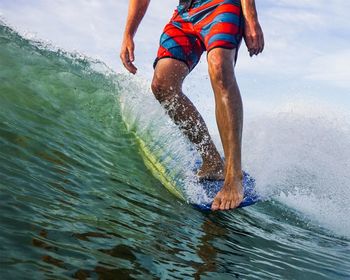 Low section of man splashing water in sea