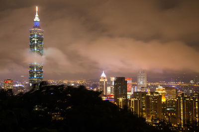 Illuminated cityscape against sky at night