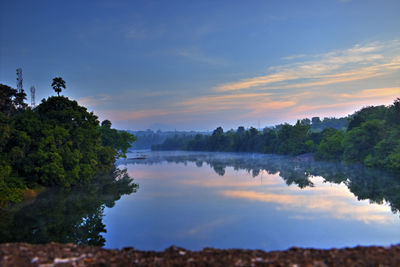 Scenic view of lake against sky at sunset