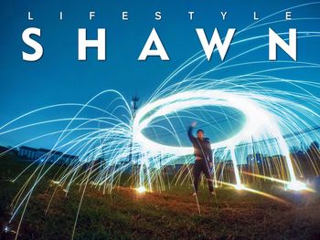 Full length of man standing by illuminated light trails at night
