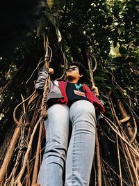 Low section of woman on rope in forest