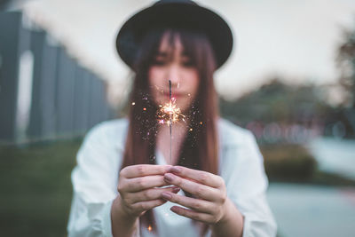 Close-up of woman holding lit sprinkler