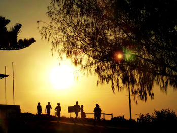 Silhouette people against sky during sunset