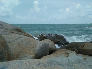 Rocks on beach against sky