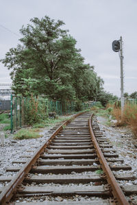 Railroad tracks by trees against sky