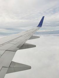 Cropped image of airplane wing against sky