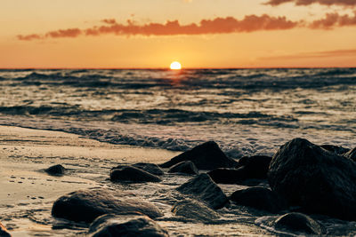 Yellow sun almost down horizon over deep blue sea at atmospheric sunset sky, scenic view