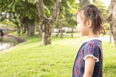 Side view of a girl standing against plants