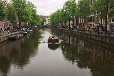 Boats in canal along buildings