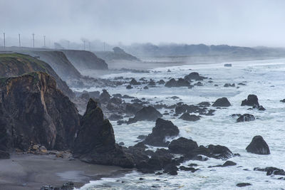 Rocks in sea against sky