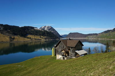 Scenic view of lake and mountains against blue sky