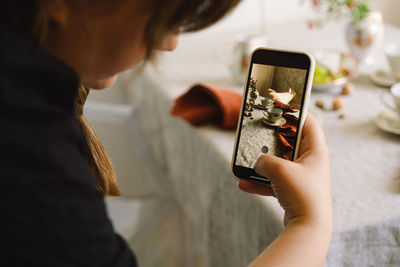 Video blog. a young woman is filming kitchen goods for her online store on her phone camera.
