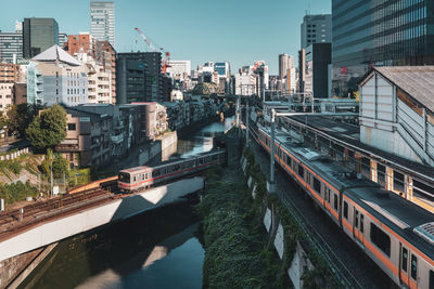 Bridge over canal amidst buildings in city against sky