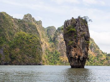 Rock formation by sea against sky