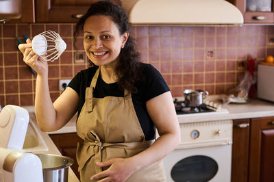 Portrait of young woman using mobile phone at home