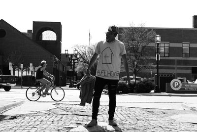 Rear view of man cycling on bicycle in city