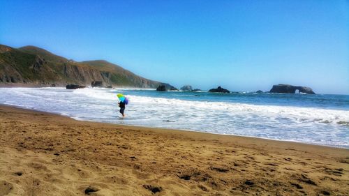 Man on beach against blue sky