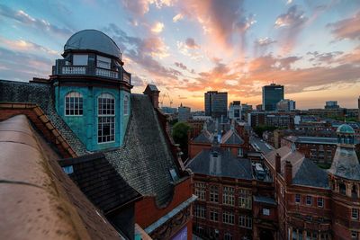 Buildings against cloudy sky at sunset