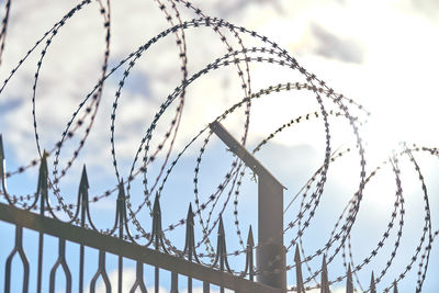 Barbed wire on fence, steel grating fence, metal fence wire. coiled razor wire with sharp barbs