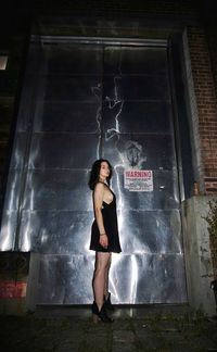 Full length of woman standing against wall