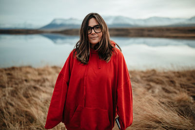 Portrait of smiling young woman standing on land