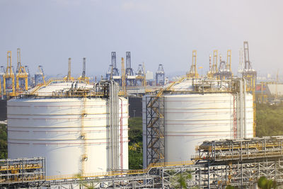 Cranes in factory against clear sky