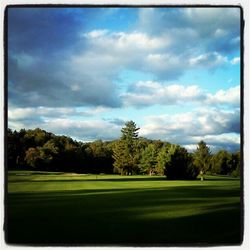 Scenic view of grassy field against cloudy sky