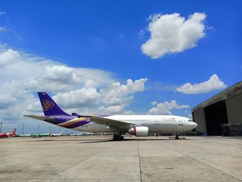 Airplane on airport runway against blue sky